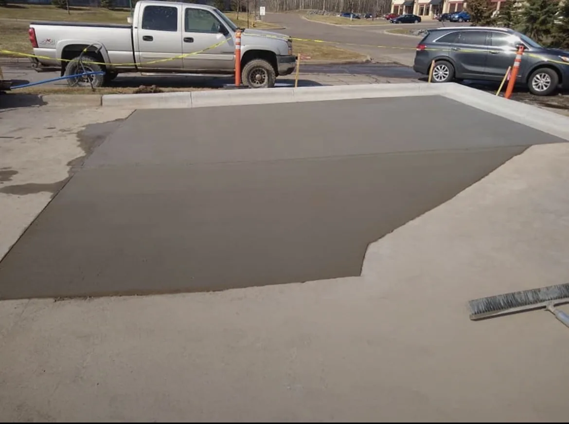 Fresh concrete driveway section beside existing pavement
