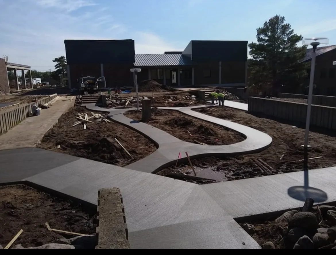 Curved concrete walkways around landscaped beds