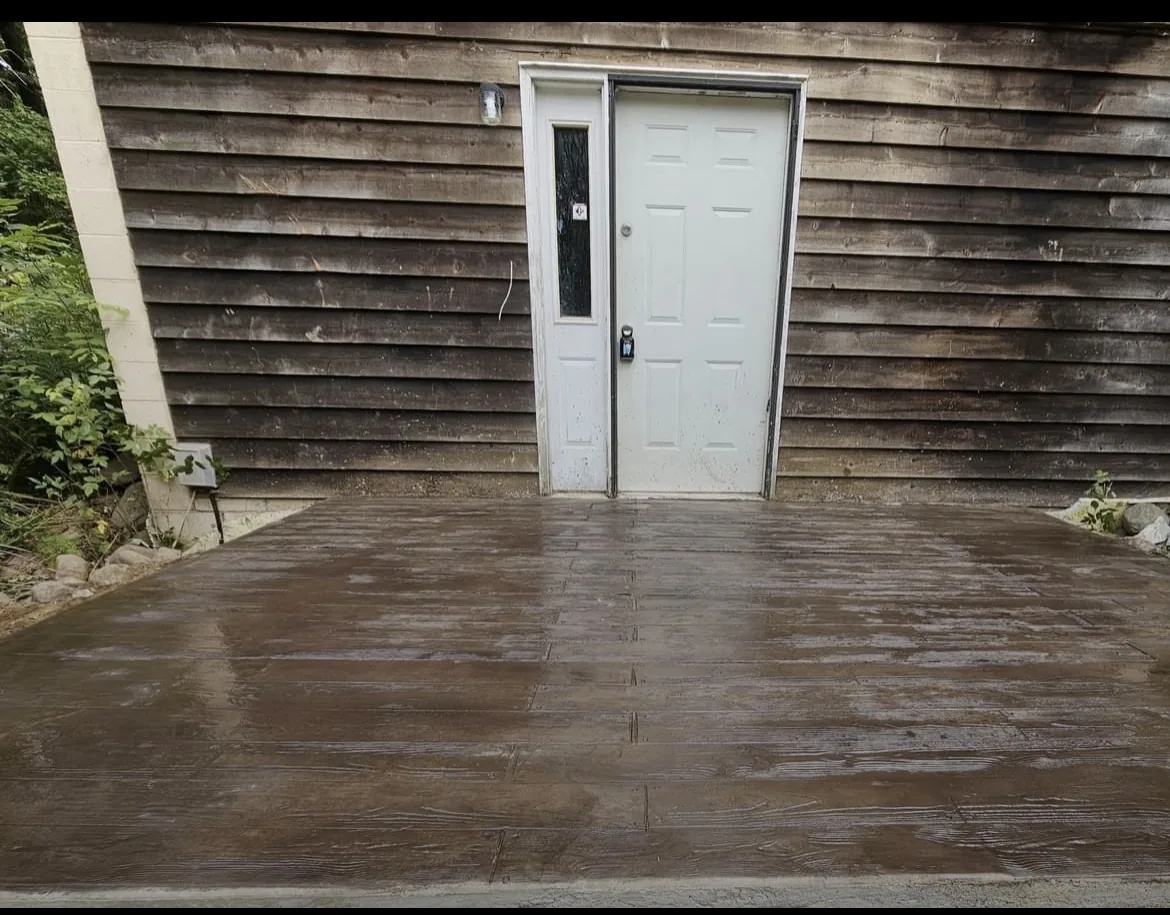 Finished concrete entry pad beside wood siding